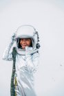 Portrait of laughing little girl wearing space suit and space hat in front of white background — Stock Photo