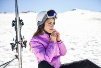 Woman taking a break after skiing sitting on the snowy ground in Sierra Nevada, Andalusia, Spain — Stock Photo