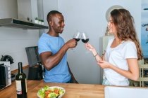 Coppia brindisi con vino in cucina — Foto stock
