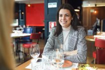 Portrait d'une femme d'affaires souriante assise à table dans un restaurant — Photo de stock