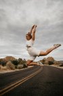 Donna che salta su strada, Joshua Tree National Park, California, USA — Foto stock