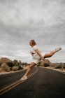 Donna che salta su strada, Joshua Tree National Park, California, USA — Foto stock