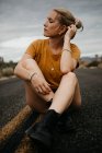 Donna seduta su strada, Joshua Tree National Park, California, USA — Foto stock