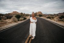 Donna felice in piedi sulla strada, Joshua Tree National Park, California, USA — Foto stock