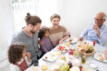 Feliz familia extendida almorzando en casa - foto de stock