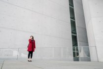 Businesswoman standing near to modern building and using smartphone — Stock Photo