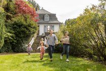 Joyeux famille élargie courir dans le jardin de leur maison — Photo de stock