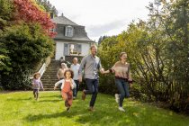 Joyeux famille élargie courir dans le jardin de leur maison — Photo de stock