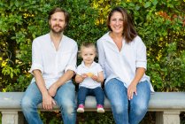 Portait de pais com filhinha sentada em um banco — Fotografia de Stock