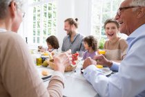 Feliz familia extendida almorzando en casa - foto de stock