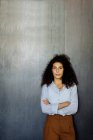 Porträt einer selbstbewussten jungen Geschäftsfrau vor einer grauen Wand — Stockfoto