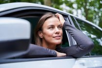 Mulher em um carro olhando para os lados — Fotografia de Stock