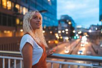 Jeune femme dans la ville au crépuscule avec rue urbaine à Londres — Photo de stock