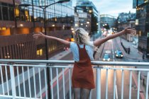 Happy and successful young woman in the city at dusk in London — Stock Photo