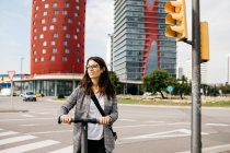 Young businesswoman with e-scooter in the city — Stock Photo