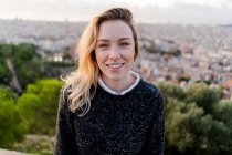 Portrait of smiling young woman at sunrise above the city, Barcelona, Spain — Stock Photo