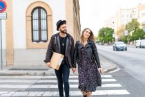 Портрет щасливої молодої пари, що переходить вулицю — стокове фото