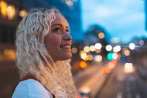 Young woman in the city at dusk with busy urban street in London — Stock Photo