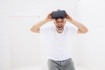 Hombre maduro con gafas VR, mirando a la cámara, riendo - foto de stock