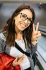 Brunette woman returning from work happy making the victory sign — Stock Photo