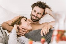 Happy young couple lying in bed — Stock Photo
