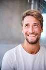 Portrait of smiling young man wearing white t-shirt — Stock Photo
