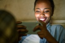Portrait of happy young woman using smartphone by night, Lisbon, Portugal — Stock Photo