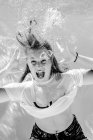 Портрет кричащей девочки-подростка в футболке, ныряющей под водой — стоковое фото