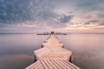 Spain, Murcia, Santiago de la Ribera, Wooden pier on calm sea at sunset — Stock Photo