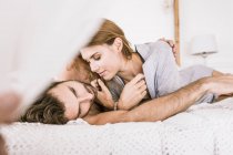 Affectionate young couple lying in bed — Stock Photo