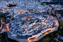 Italia, Provincia di Brindisi, Ostuni, Veduta aerea della cittadella del centro storico circondata da case bianche al tramonto — Foto stock