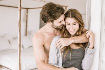 Affectionate young couple in bedroom — Stock Photo
