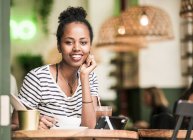 Portrait de jeune femme souriante dans un café — Photo de stock