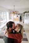 Couple heureux embrasser et embrasser dans leur maison confortable — Photo de stock