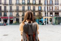 Rear viewof young woman with backpack in the city, Barcelona, Spain — Stock Photo