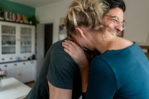 Glückliches Paar umarmt sich in Küche zu Hause — Stockfoto