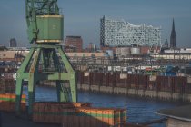 Germany, Hamburg, Harbor crane with Elbphilharmonie in background — Stock Photo
