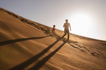 Vater und Tochter laufen bei Sonnenuntergang in einer Sanddüne, Gran Canaria, Spanien — Stockfoto
