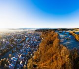 Alemania, Baviera, Wolfratshausen, Drone vista de la ciudad en las estribaciones alpinas en el amanecer de invierno - foto de stock