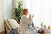 Young woman using smartphone at home — Stock Photo