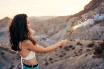 Young woman with sparkler at sunset, Almeria, Spain — Stock Photo