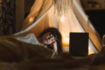 Retrato de menina deitada na cama com laptop — Fotografia de Stock
