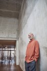 Uomo d'affari creativo appoggiato al muro nel suo ufficio minimalista — Foto stock