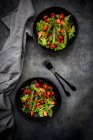Two bowls of vegetarian salad with lettuce, strawberries and asparagus — Stock Photo