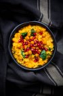 Ciotola di curry vegano con lenticchie rosse, patate dolci, spinaci, ceci arrosto di curcuma, semi di melograno e coriandolo — Foto stock