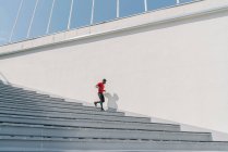Sportsman wearing mask running down stairs — Stock Photo