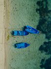 Indonesia, Bali, Sanur, Aerial view of blue boats moored in front of sandy coastal beach — Stock Photo