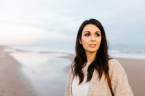 Porträt einer jungen Frau an einem abgelegenen Strand bei Sonnenuntergang — Stockfoto