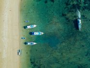 Indonesia, Bali, Sanur, Aerial view of boats moored in front of sandy coastal beach — Stock Photo
