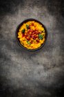 Colpo in studio di ciotola di curry vegano con lenticchie rosse, patate dolci, spinaci, ceci arrosto di curcuma, semi di melograno e coriandolo — Foto stock